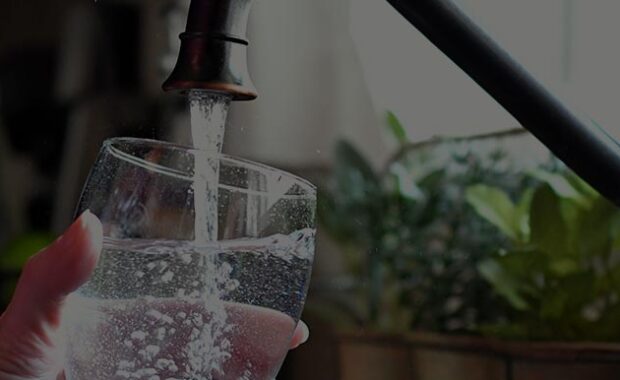 Pouring Water Into A Glass From The Kitchen Faucet
