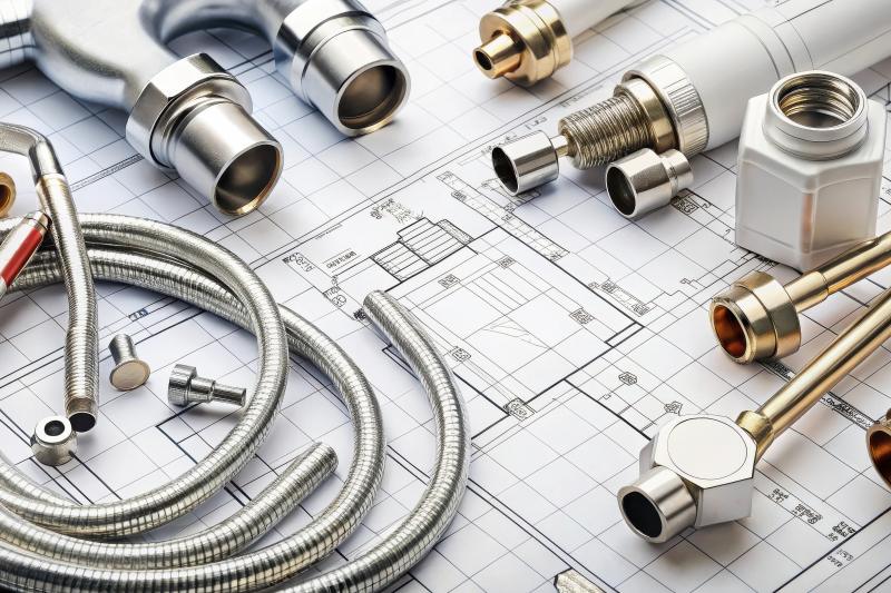 A variety of plumbing fixtures arranged on a blueprint, showcasing the intricate details and complexities of modern plumbing design
