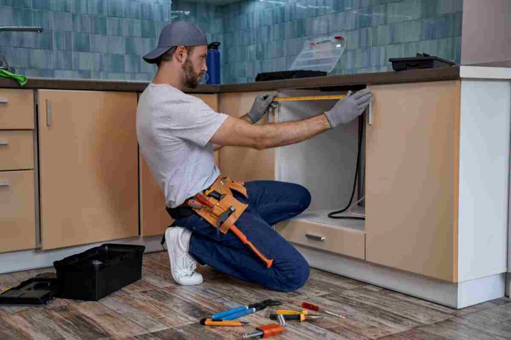 repairman measuring size of kitchen drawer