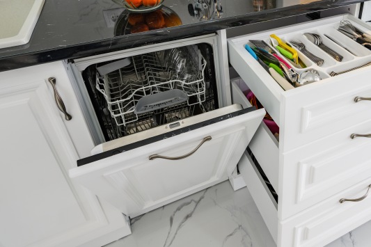 Luxurious white modern kitchen interior, drawers pulled out, dishwasher's door open, high angle