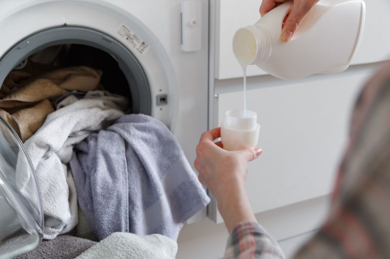 Woman Pouring Laundry Detergent