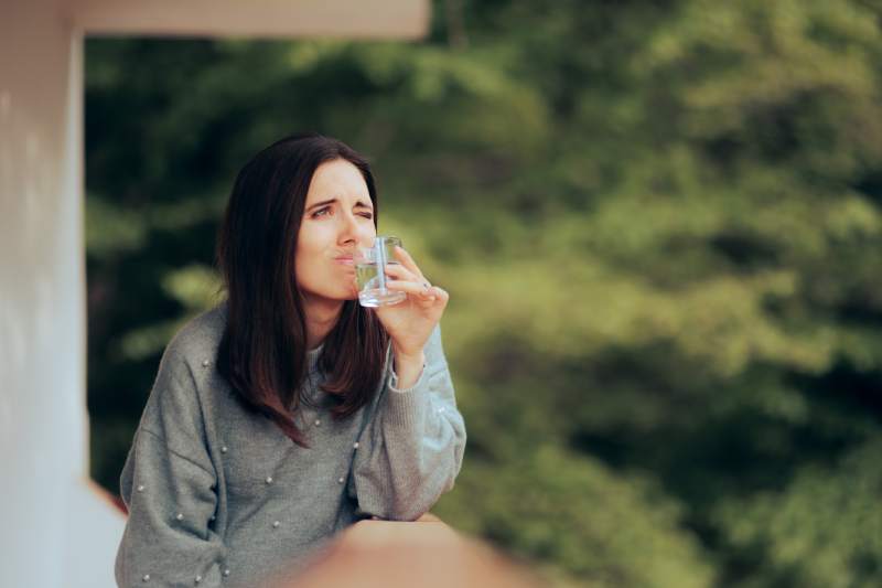 Woman With Glass Of Water That Smells Like Rotten Eggs