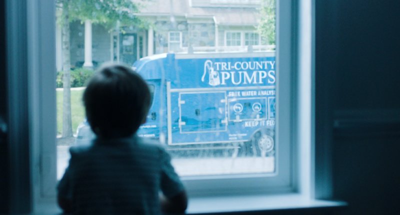 Boy Staring Out Of His Window At The Tri-County Pumps Well Repair Service Truck
