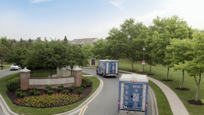 Tri-County Pumps Trucks Leaving A House After Performing Plumbing Services