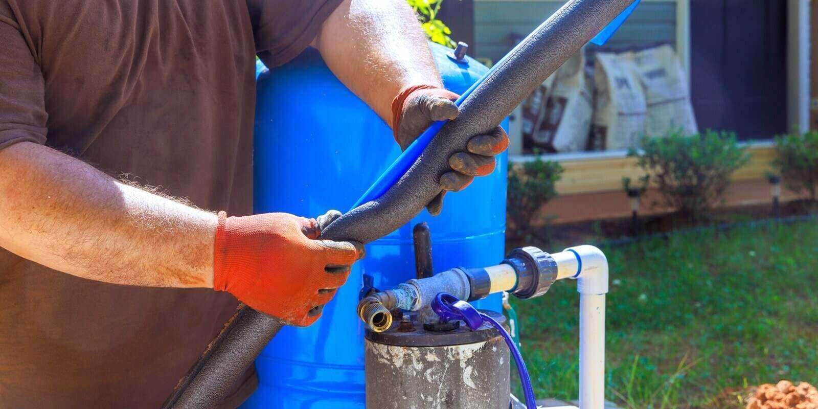 contractor installs hoses connect to water well fittings on an irrigation system in backyard works day