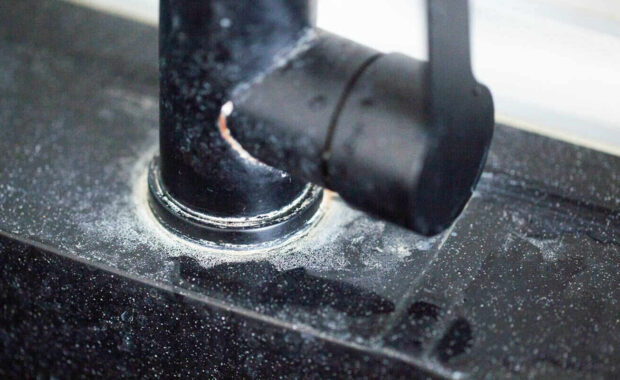 white scale from hard water on black bathroom faucets