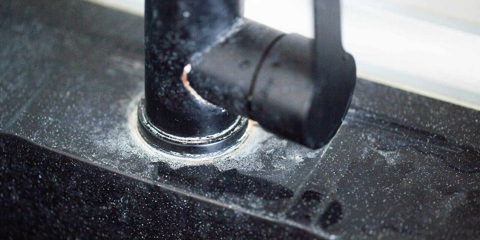 white scale from hard water on black bathroom faucets