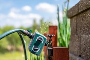 garden water timer on a spigot with a splitter and hoses