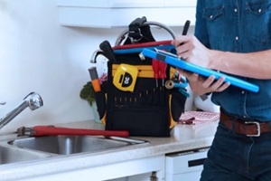 photo of plumber fixing the faucet in the kitchen