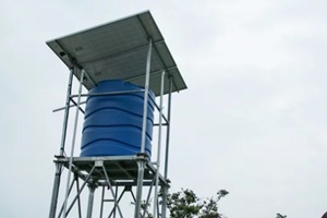 blue plastic water tank mounted on a metal tower, topped with solar panels, designed for sustainable water storage and distribution