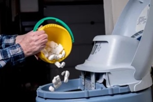 homeowner adds salt to a water softener