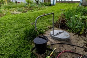 a garden with a water pump in the middle of it